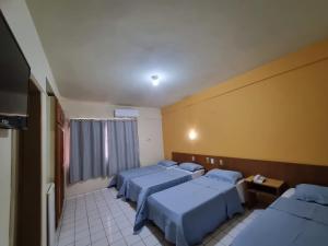 a hospital room with three beds and a window at Ambassador Hotel in Foz do Iguaçu