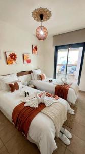 a hotel room with three beds with towels on them at La Cala Center Premium Penthouse Motorized Terrace & Sea Views in La Cala de Mijas
