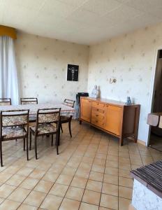 a dining room with a table and chairs and a cabinet at Maison Atypique 5 chambres in Le Mans