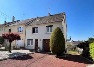 a house with a large bush in front of it at Maison Atypique 5 chambres in Le Mans