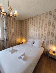 a bedroom with a large white bed with towels on it at Maison Atypique 5 chambres in Le Mans