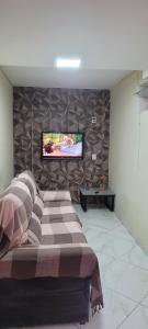 a bedroom with a bed and a tv on a wall at Apartamento 2 Quartos com Garagem e Ar Condicionado próximo do centro 3km in Cachoeiro de Itapemirim