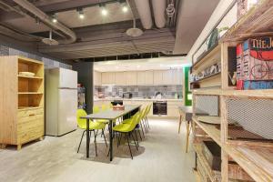 a kitchen with a dining table and yellow chairs at Taiwan Youth Hostel & Capsule Hotel in Taipei