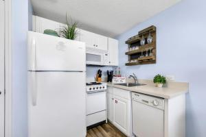 a kitchen with white appliances and a white refrigerator at Beachfront Studio #909 at Majestic in Panama City Beach +49 photos