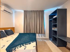 a bedroom with a bed and a book shelf at Apartamento de 1 quarto com sofá-cama no centro para até 4 pessoas in Brusque