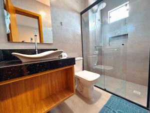 a bathroom with a shower and a sink and a toilet at Apartamento de 1 quarto com sofá-cama no centro para até 4 pessoas in Brusque +23 photos