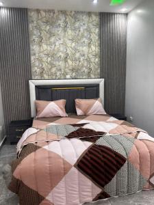 a bedroom with two beds with pink and brown comforters at Studio standing in Dakar