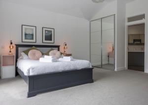 a bedroom with a large bed with white sheets and pink pillows at 38 Venn Park in Stoke Fleming