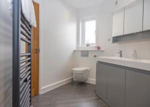 a white bathroom with a toilet and a sink at 38 Venn Park in Stoke Fleming