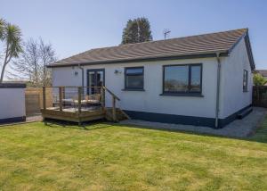 a small white house with a porch and a yard at 38 Venn Park in Stoke Fleming