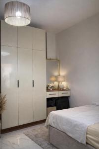 a bedroom with a bed and a large white cabinet at Arian North Coast Chalet Santorini Resort El Alamein in El Alamein +18 photos