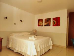 a bedroom with a bed and two paintings on the wall at Hotel Marluz in Mejillones +4 photos