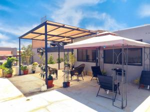 a patio with an umbrella and chairs and a table at Hotel Marluz in Mejillones