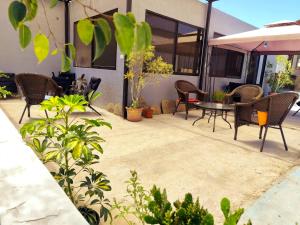a patio with wicker chairs and a table in front of a building at Hotel Marluz in Mejillones
