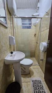 a bathroom with a toilet and a sink at Hotel Alvorada in Alegrete