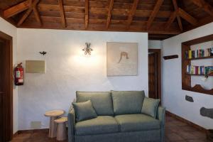 a living room with a couch and a book shelf at Villa El Topo -Piscina privada - Private pool - by Rural La Palma in El Pinillo