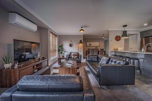 ein Wohnzimmer mit zwei Sofas und einer Küche in der Unterkunft Tranquility in Oberon