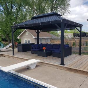a pavilion over a pool with a blue couch under it at Picturesque Luxury Waterside Villa in Niagara Falls