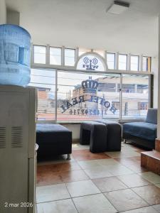 a living room with couches and a large window at Hotel Real, Villa Garzón in Villagarzón