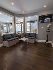 a living room with two couches and a table at Picturesque Luxury Waterside Villa in Niagara Falls