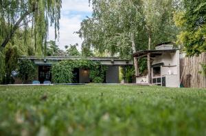 a house with a green lawn in front of it at Encantadora casa de campo in Ciudad Lujan de Cuyo