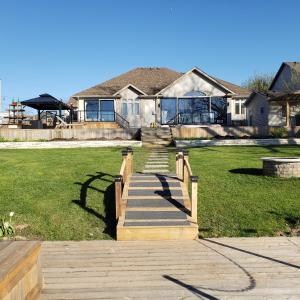 a house with a staircase in front of a yard at Picturesque Luxury Waterside Villa in Niagara Falls