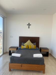 a bedroom with a bed with a cross on the wall at Departamento en Yatay Towers in Hércules +4 photos