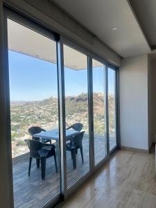 a room with a table and chairs and windows at Departamento en Yatay Towers in Hércules