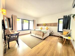 a bedroom with a bed and a desk and some windows at ōku in Monchique +124 photos