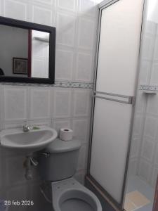 a bathroom with a toilet and a sink and a mirror at Hotel Real, Villa Garzón in Villagarzón +46 photos