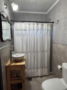 a bathroom with a shower curtain and a sink at Carpe diem CyC in Chascomús +8 photos