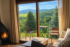 a living room with a large window with a view of the mountains at Allotjaments Vall de Muntanyes in Molló