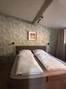 a bed with two pillows on it in a bedroom at Baumhausfeeling im Wald nahe der Loreley in Bogel