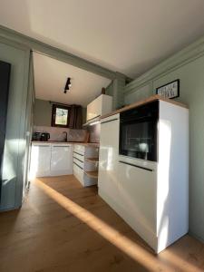 a kitchen with white cabinets and a white oven at Baumhausfeeling im Wald nahe der Loreley in Bogel
