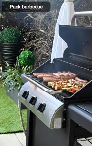 a grill with hot dogs and vegetables on it at RedLounge - Appartement avec Piscine et Jardin in Toulouse