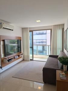 a living room with a couch and a flat screen tv at Blue Hope, 467, LUXO em Vitória ES in Vitória