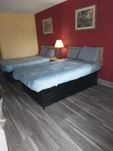 two beds in a bedroom with a red wall at 2 Queen Beds Hotel Room 237 in Jackson
