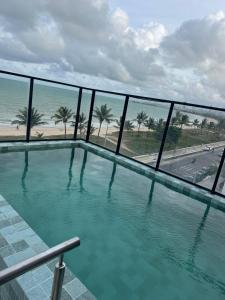 a swimming pool with a view of the ocean at G5 Beach Flat Intermares 304 in Cabedelo