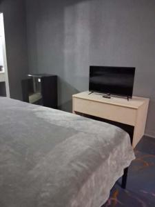 a bedroom with a bed and a desk with a television at King Bed Hotel Room 255 in Jackson