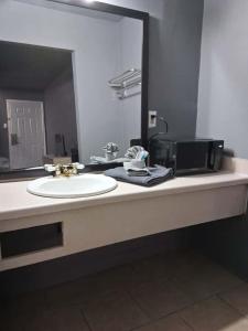 a bathroom counter with a sink and a mirror at King Bed Hotel Room 255 in Jackson