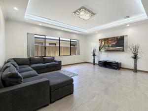 a living room with a couch and a tv at Spacious 4 bed home with open plan living in Perth