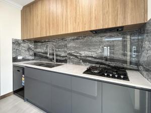a kitchen with a sink and a stove at Spacious 4 bed home with open plan living in Perth