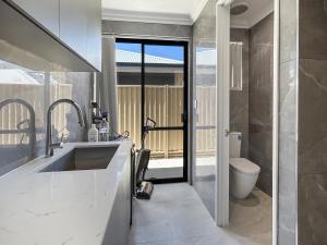 a bathroom with a sink and a toilet at Spacious 4 bed home with open plan living in Perth