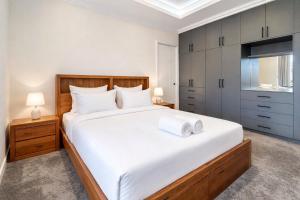 a bedroom with a large white bed and cabinets at Spacious 4 bed home with open plan living in Perth +9 photos