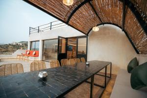 a dining room with a black table and chairs at Surf Lodge Tamraght in Tamraght Ouzdar