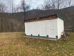 a smallshed with white doors in a field at Camp Budečevica in Žabljak