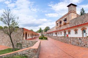 a building with a stone wall and a brick sidewalk at Centro Vacacional La Trinidad in Santa María Atlihuetzián