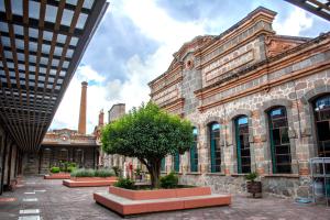 an old building with a tree in a courtyard at Centro Vacacional La Trinidad in Santa María Atlihuetzián