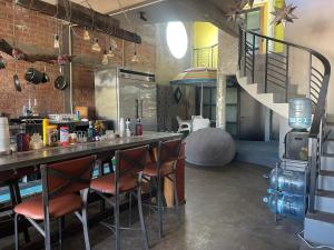 a kitchen with a bar with chairs and a staircase at Casa Maruja CoLiving Walk to Beach in Puerto Vallarta