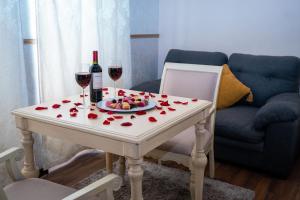 a table with two glasses of wine and a plate of fruit at Hotel Embajada in San Luis Potosí